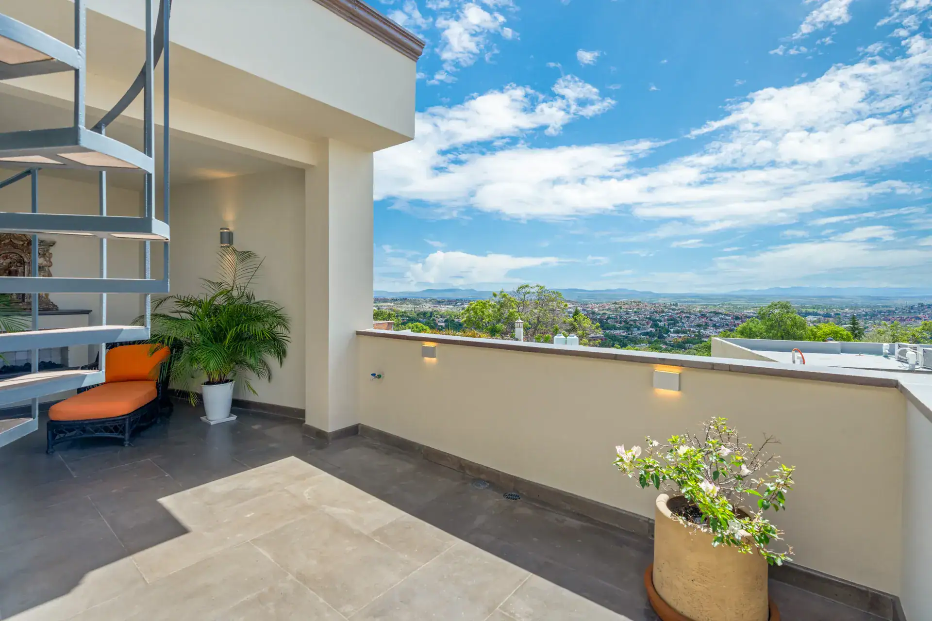 Suites Casa Vistas, rooftop terrace with a spiral staircase, orange lounge chair and a view of the valley, San Miguel de Allende