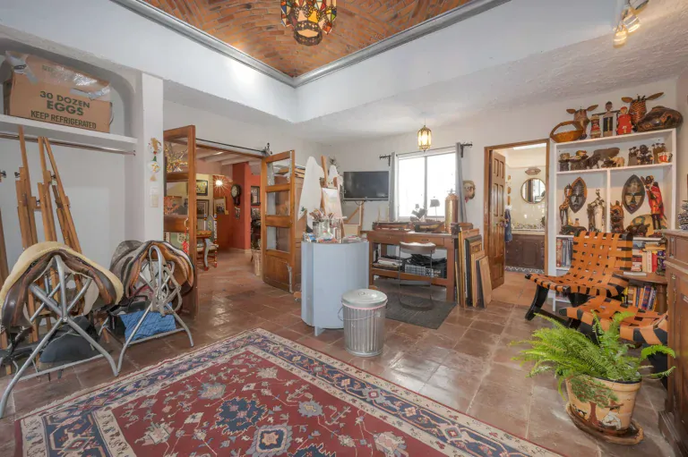 Two Homes, studio-style room with easels, tool stands, a wood workbench and framed paintings on the walls, San Miguel de Allende
