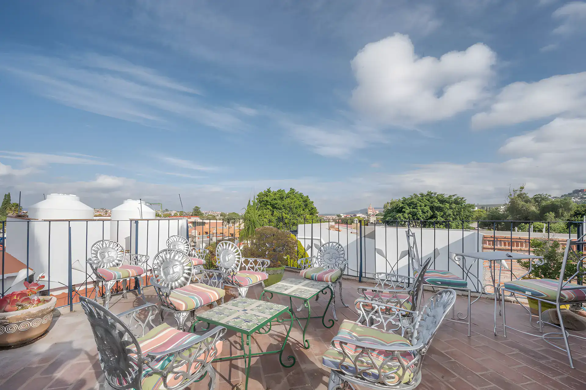 Two Homes, rooftop lounge with sun-themed metal chairs and tile-top tables overlooking the sky, San Miguel de Allende