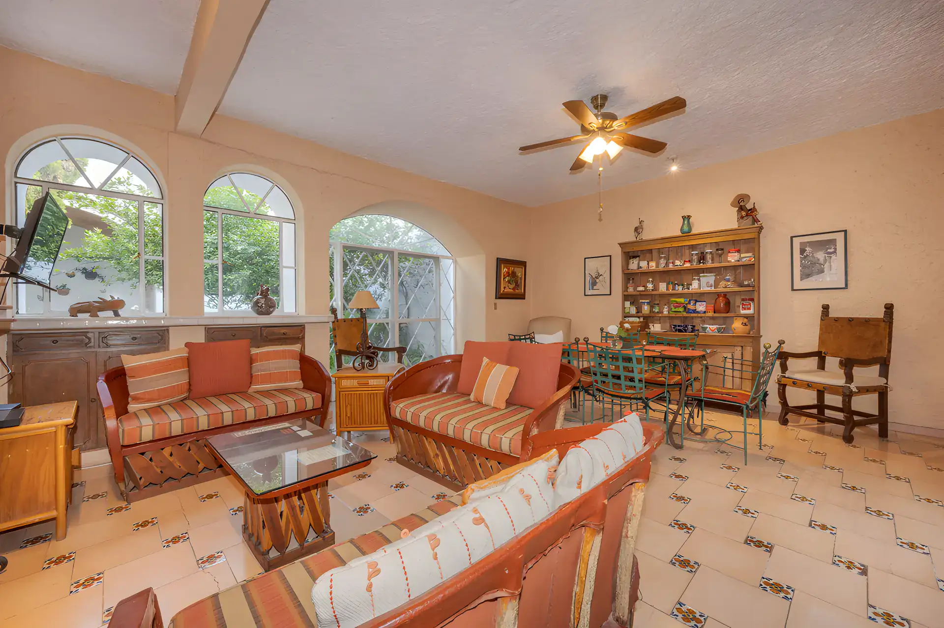 Two Homes, guest apartment living room with striped equipale sofas and arched windows, San Miguel de Allende