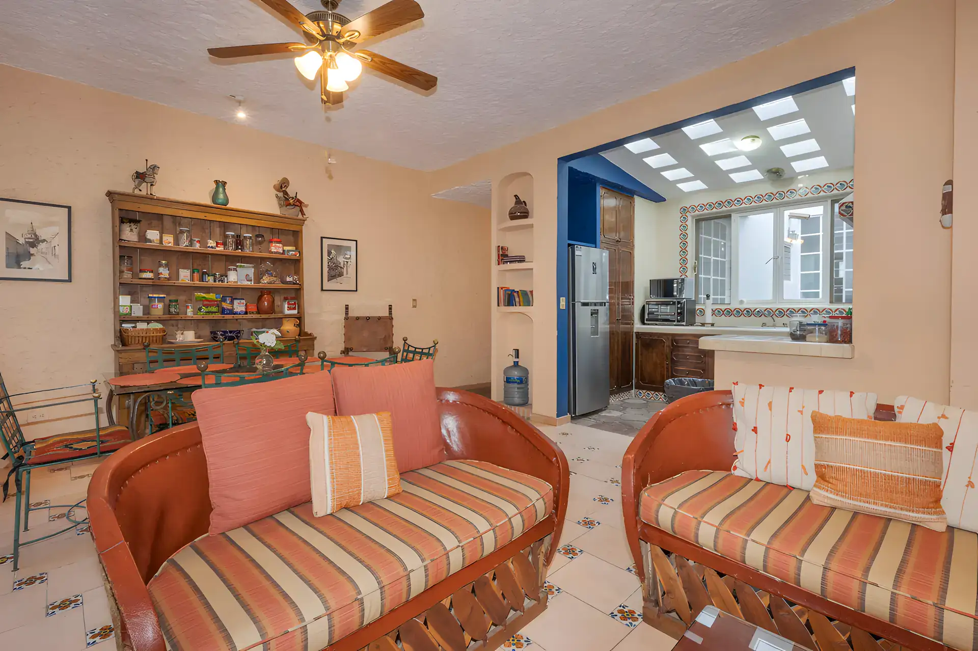 Two Homes, guest apartment living area with striped sofas, a wood hutch and a kitchen with a blue frame, San Miguel de Allende