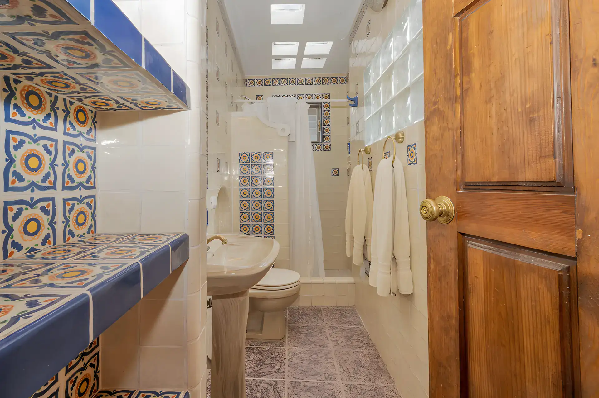 Two Homes, bathroom with Talavera tile, a tiled counter and a shower with a glass block wall, San Miguel de Allende