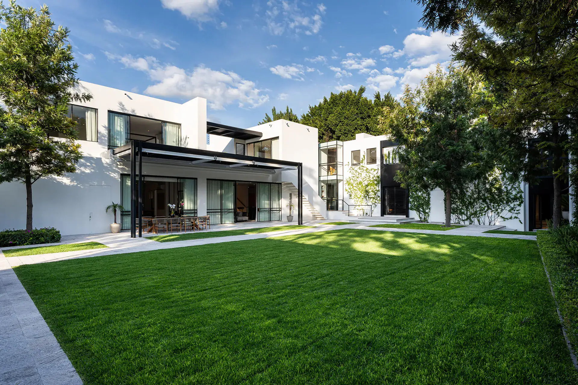 Villa del Parque Central, white two-story villa and manicured lawn under a blue sky, San Miguel de Allende