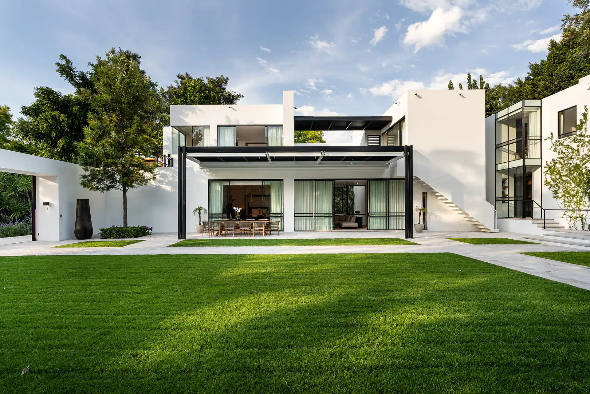 Villa del Parque Central, contemporary villa with covered dining terrace, exterior staircase and green lawn, San Miguel de Allende
