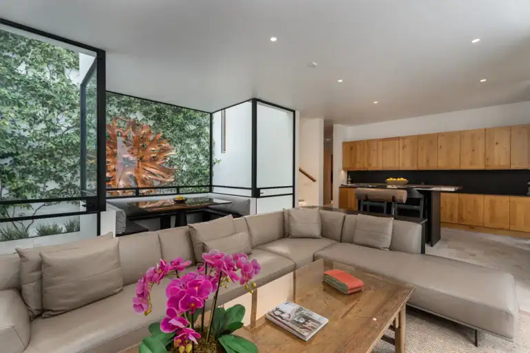 Villa del Parque Central, sectional sofa and orchid in front of the open kitchen with oak cabinetry, San Miguel de Allende