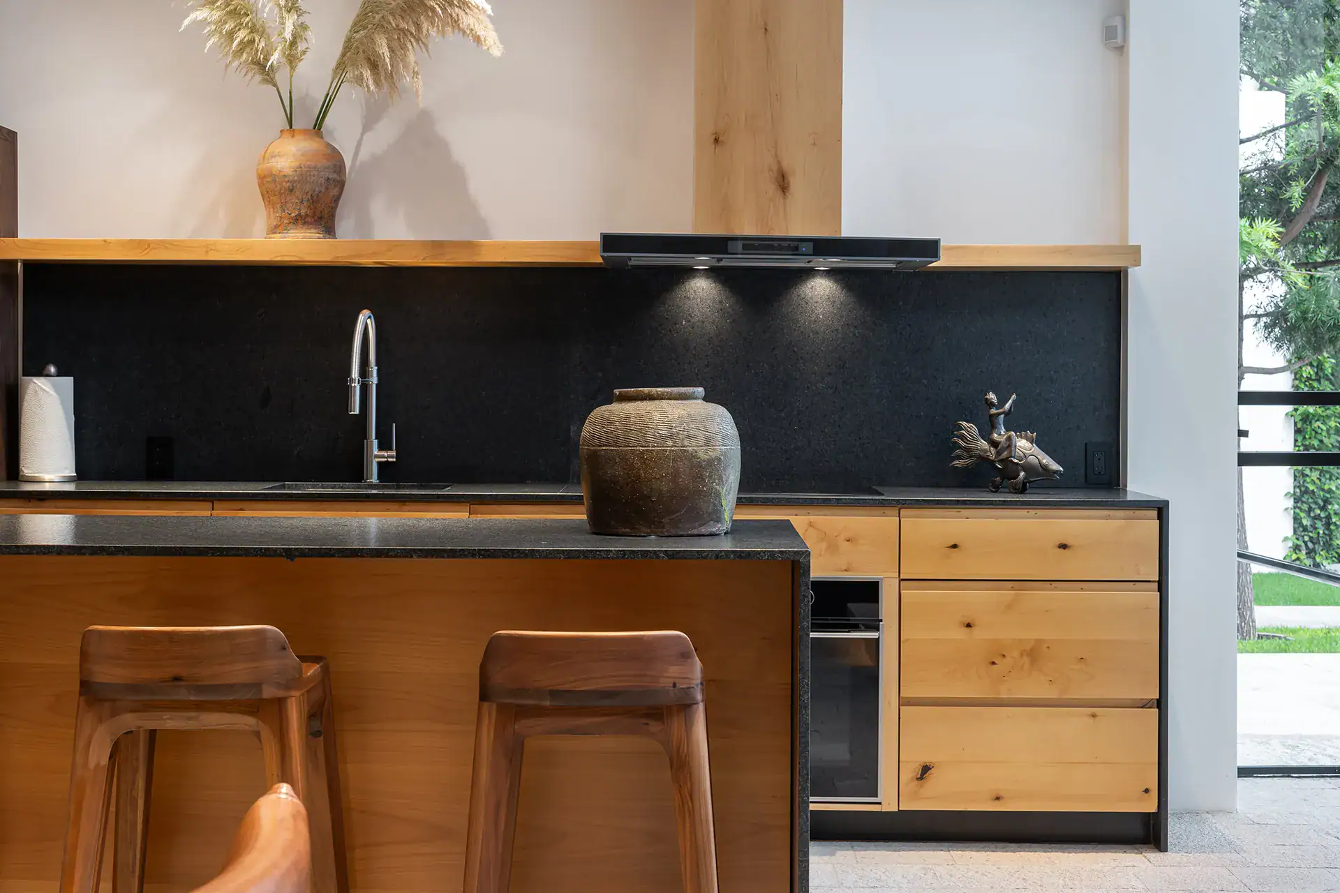 Villa del Parque Central, kitchen with oak cabinets, black backsplash and wooden bar stools, San Miguel de Allende