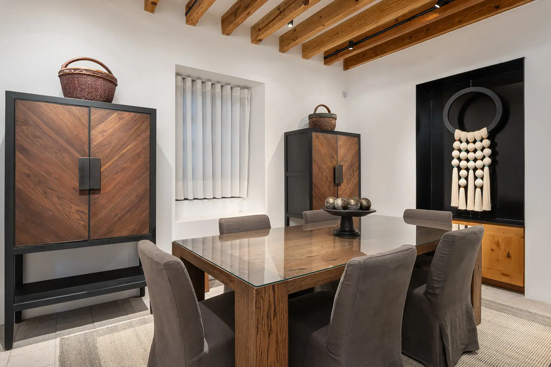 Villa del Parque Central, dining table with gray slipcovered chairs beside a chevron-pattern wood cabinet, San Miguel de Allende
