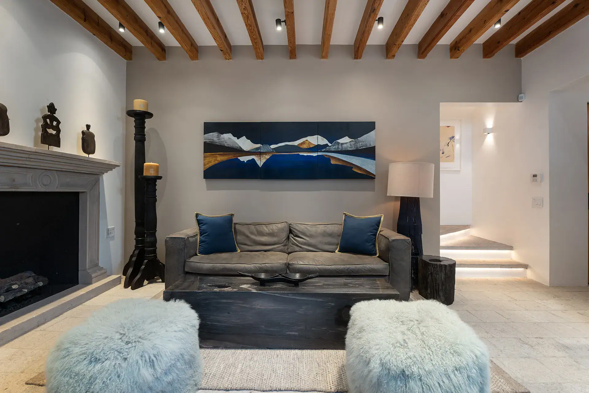 Villa del Parque Central, living room with a stone fireplace, leather sofa and pale blue sheepskin ottomans, San Miguel de Allende
