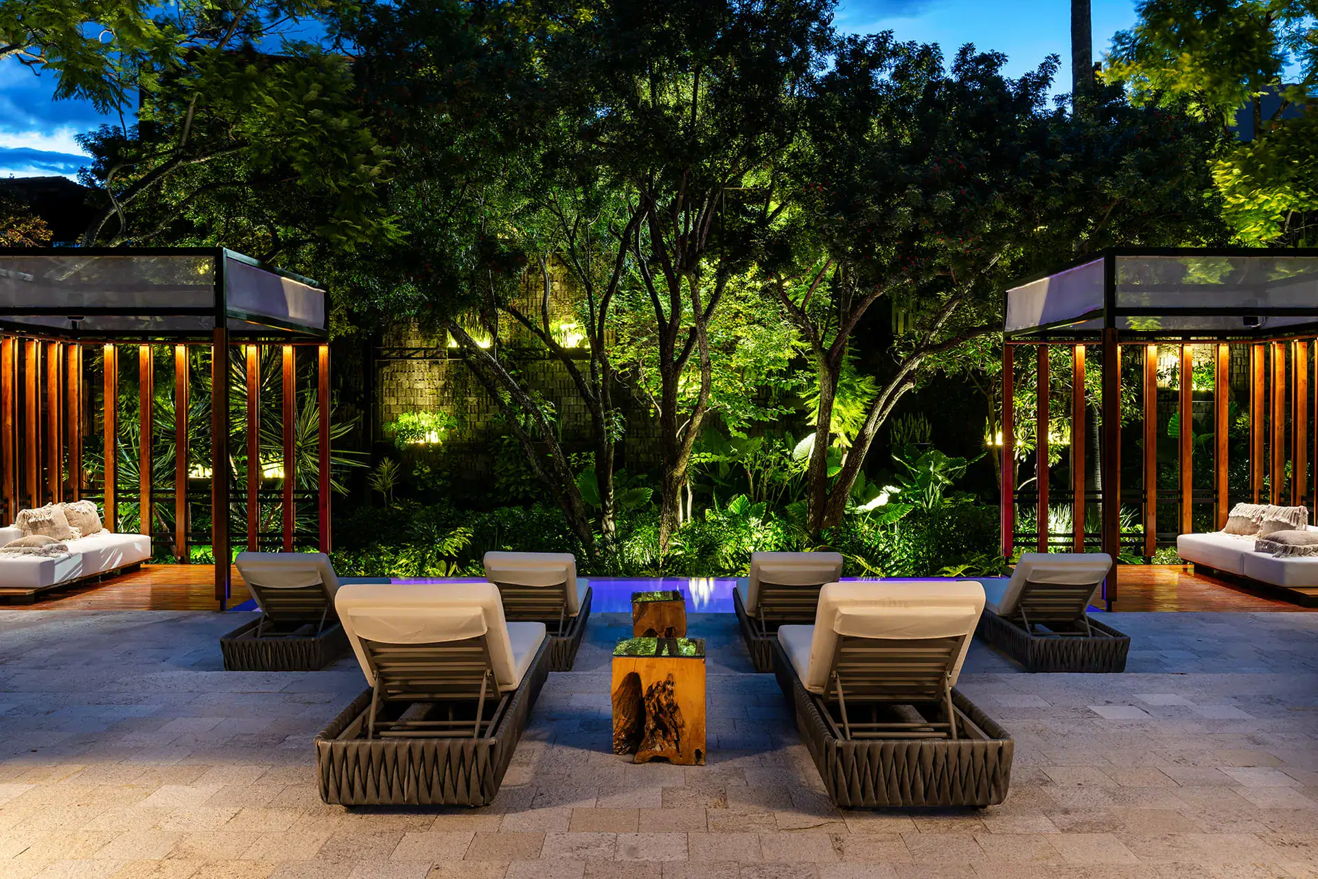Villa del Parque Central, lounge chairs and wood-slat cabanas around the pool terrace at night, San Miguel de Allende