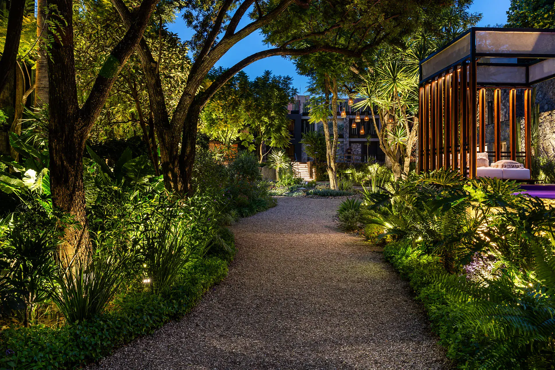 Villa del Parque Central, gravel garden path lit at night leading past a pool cabana, San Miguel de Allende