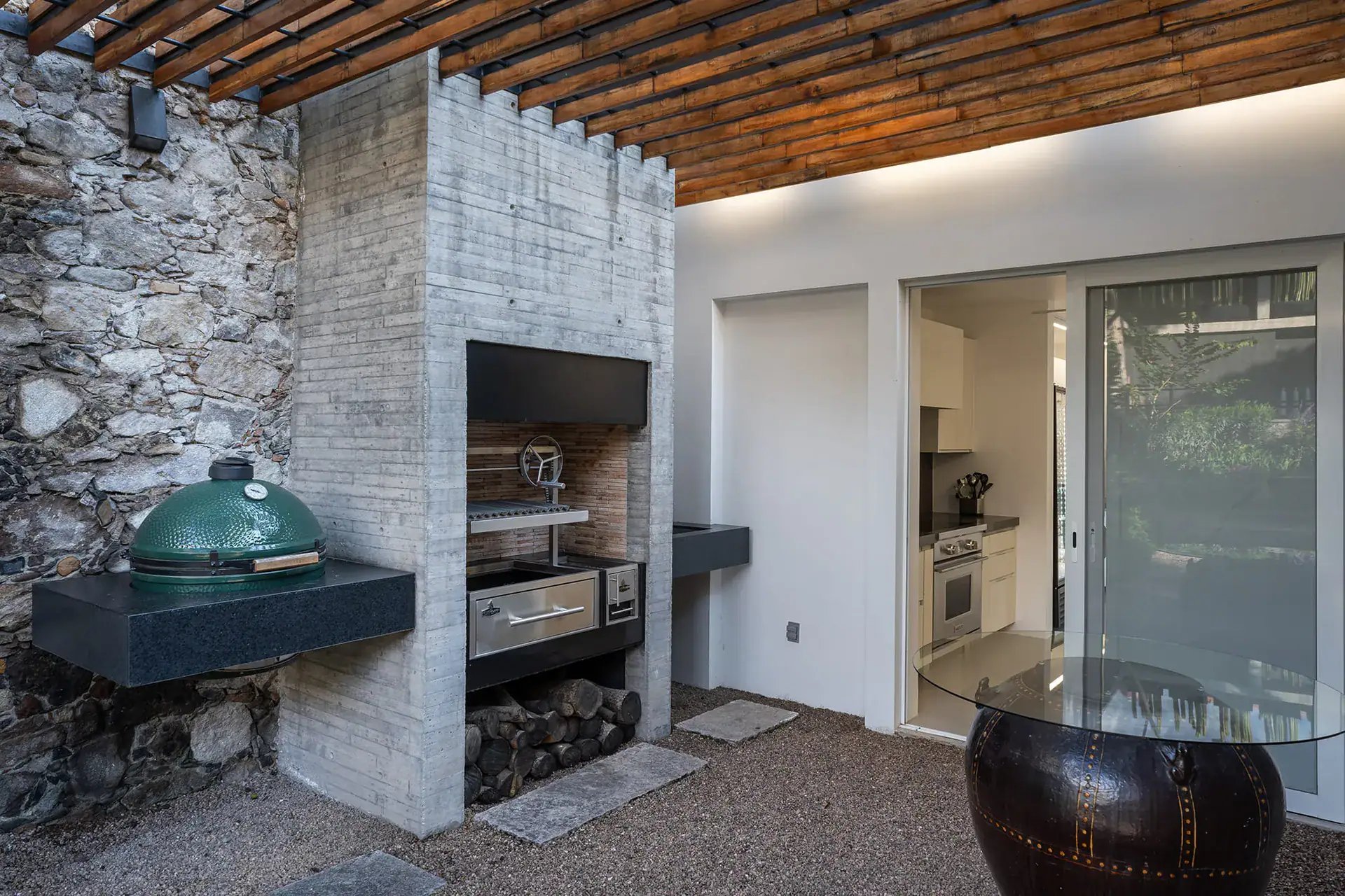 Villa del Parque Central, outdoor kitchen with a built-in grill and a green ceramic cooker under a wood pergola, San Miguel de Allende