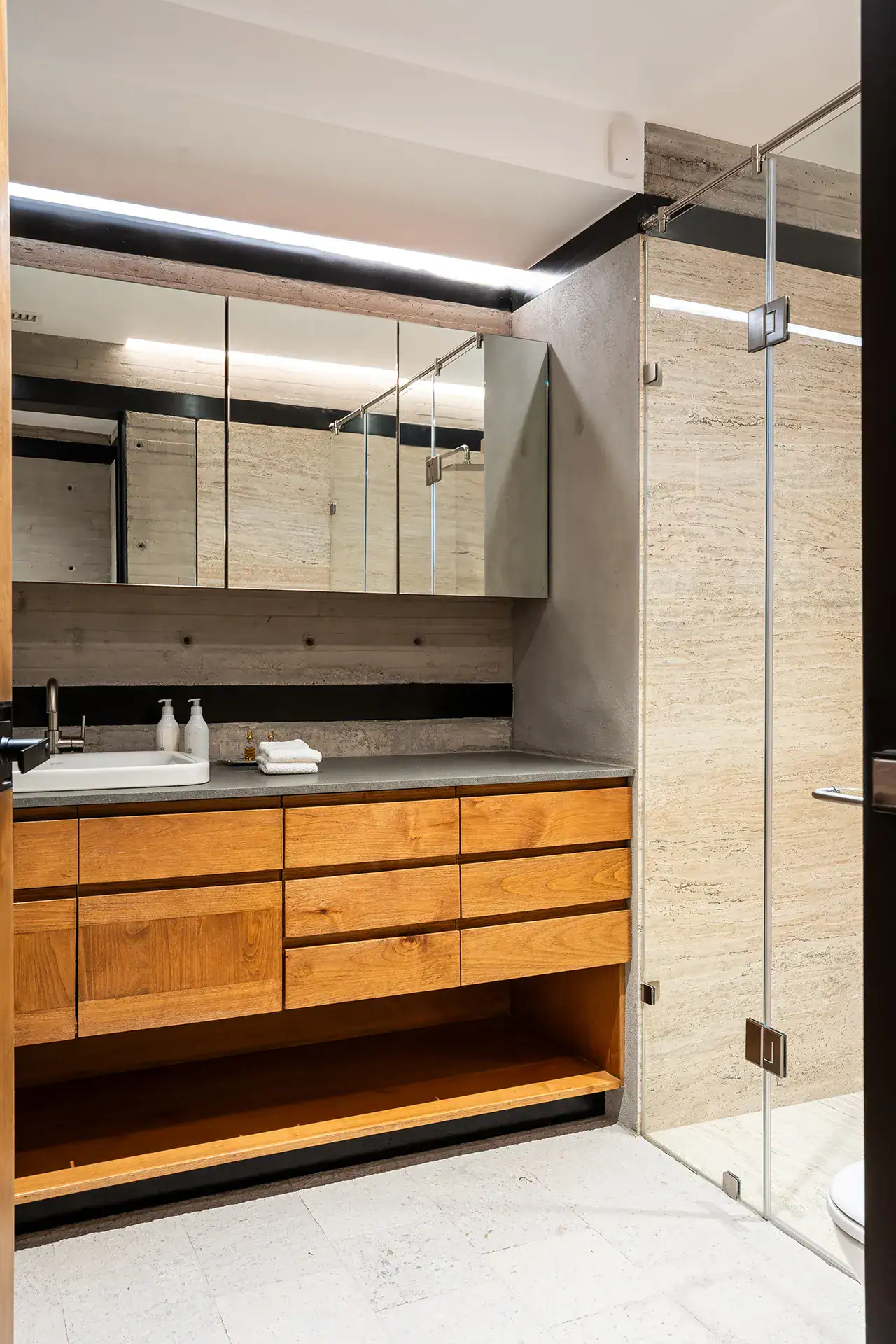 Villa del Parque Central, lower-level bathroom with an oak vanity, mirrored cabinets and a glass shower, San Miguel de Allende