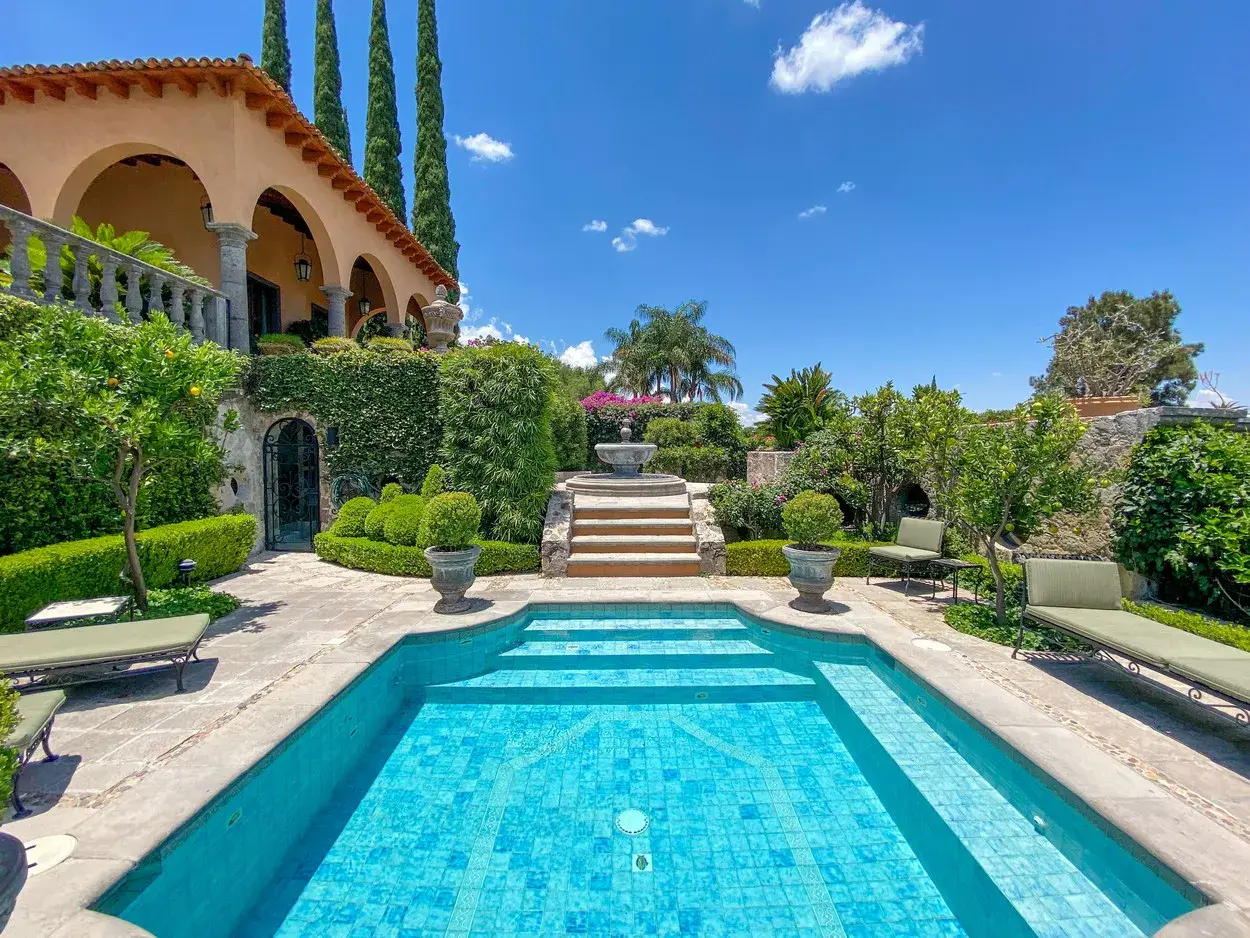 Villa Entre Sueños, rectangular pool framed by hedges and cypress trees, San Miguel de Allende