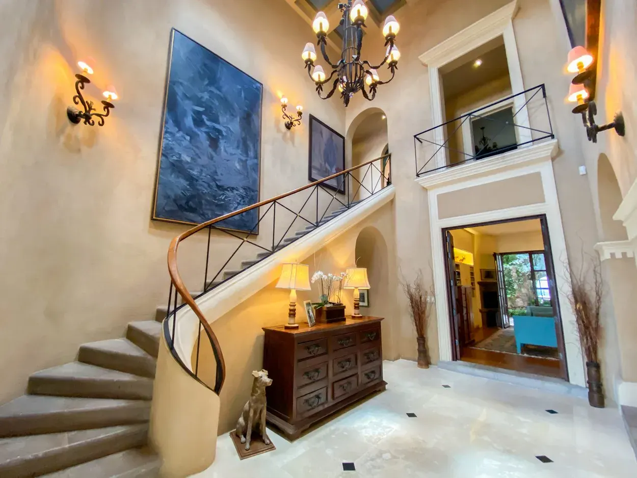 Villa Entre Sueños, entry hall with a spiral staircase and a wrought-iron chandelier, San Miguel de Allende