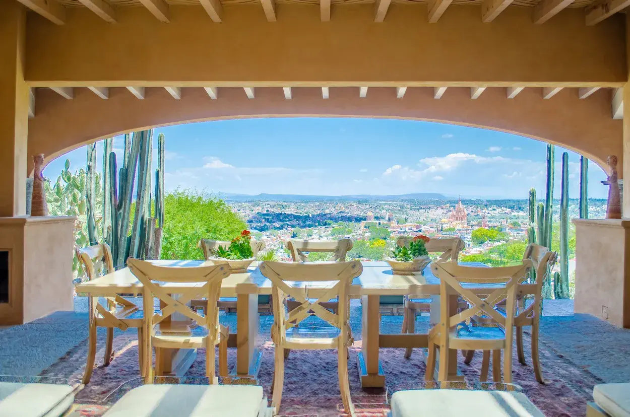 Villa Entre Sueños, open-air dining table framed by an arch with a view of the city, San Miguel de Allende