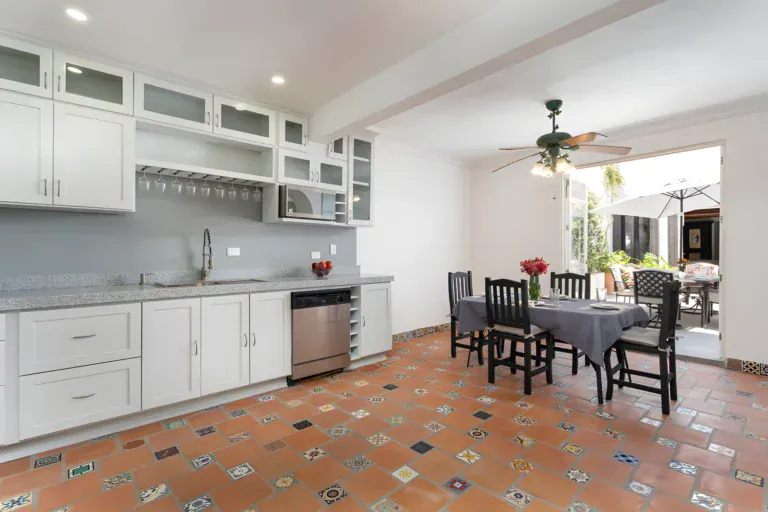 Villa Escondida, kitchen with white cabinets, gray backsplash and a dining table set for four, San Miguel de Allende