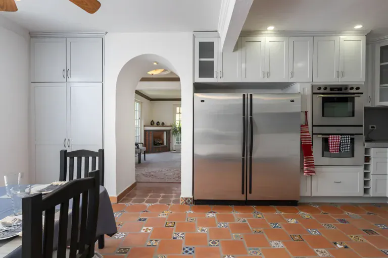 Villa Escondida, kitchen with a stainless double oven and refrigerator and an arch to the living room, San Miguel de Allende