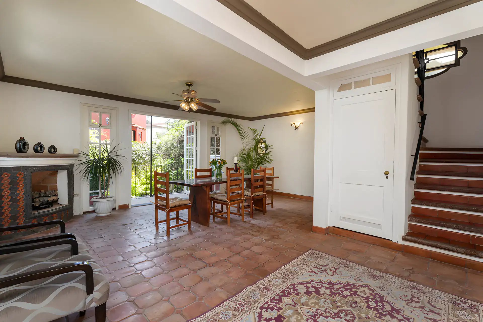 Villa Escondida, dining room with a rug, a staircase and garden doors, San Miguel de Allende