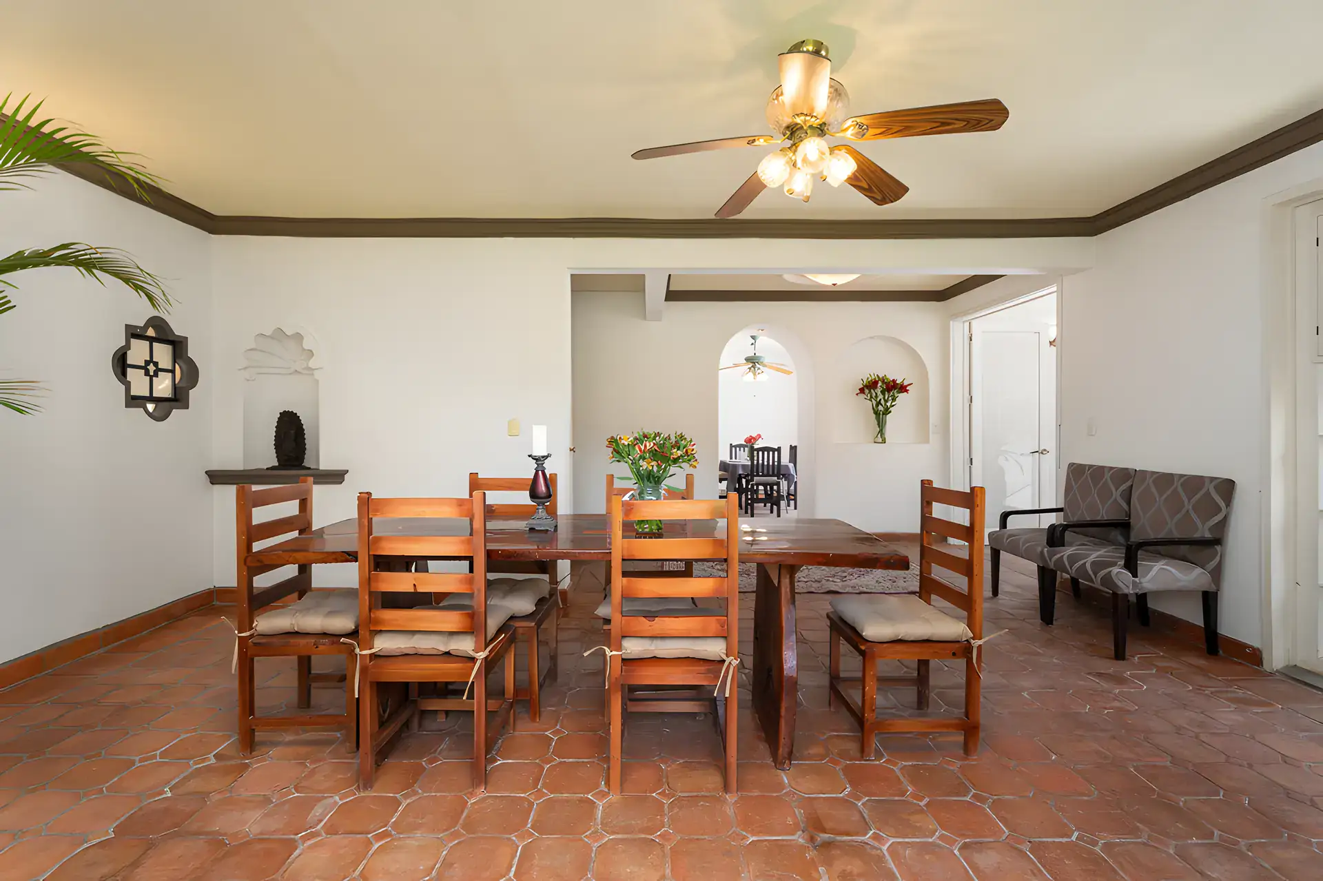 Villa Escondida, dining room with a long wood table, wall niches and a ceiling fan, San Miguel de Allende