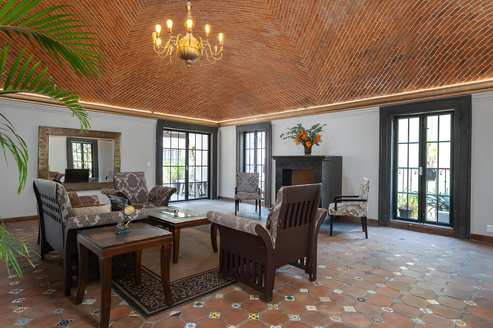 Villa Escondida, living room with patterned sofas, a fireplace and French doors under a brick vaulted ceiling, San Miguel de Allende