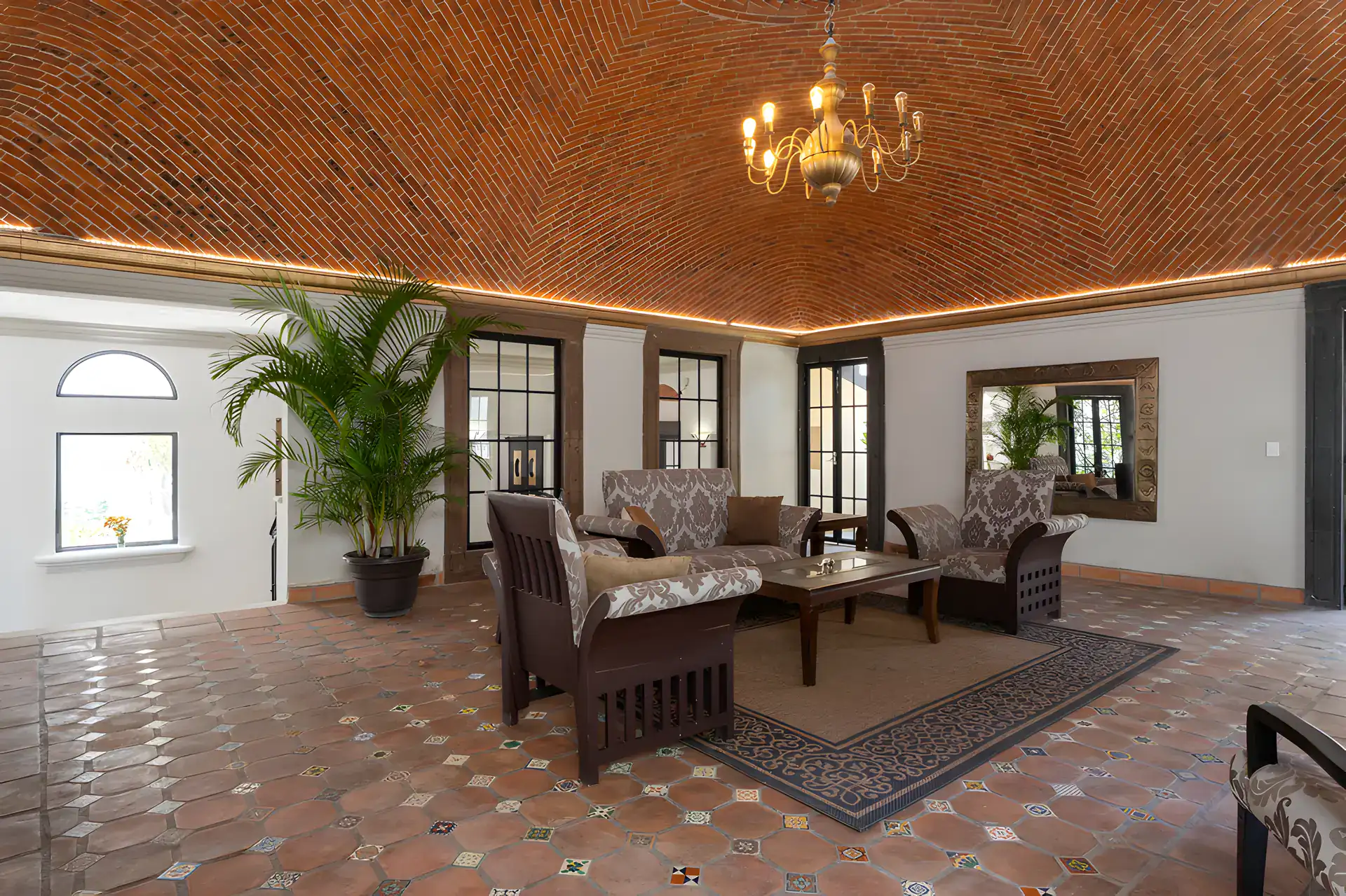 Villa Escondida, living room with a patterned seating group, rug and an arched window, San Miguel de Allende
