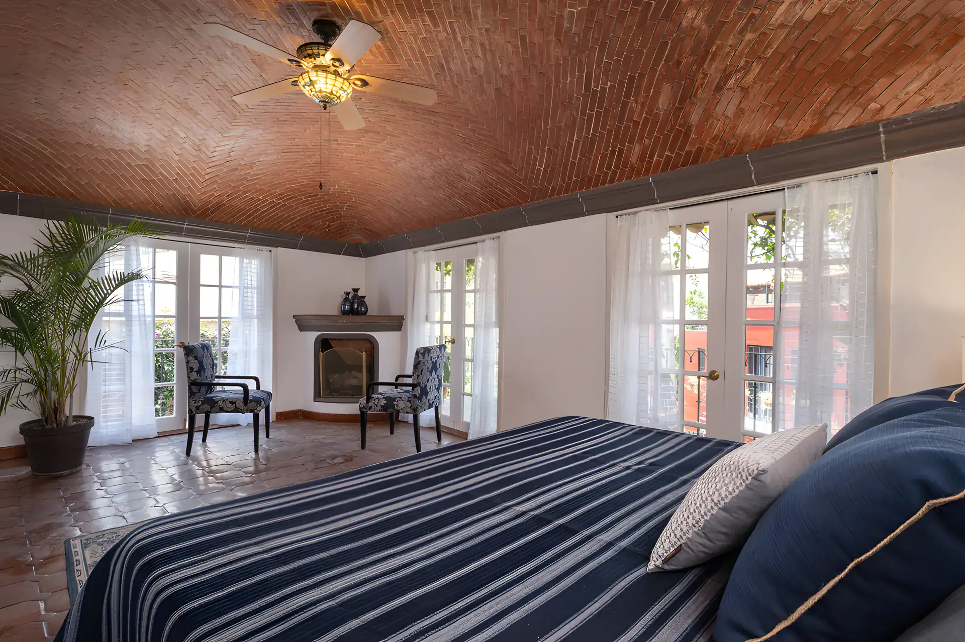 Villa Escondida, bedroom with a corner fireplace, ceiling fan and French doors, San Miguel de Allende