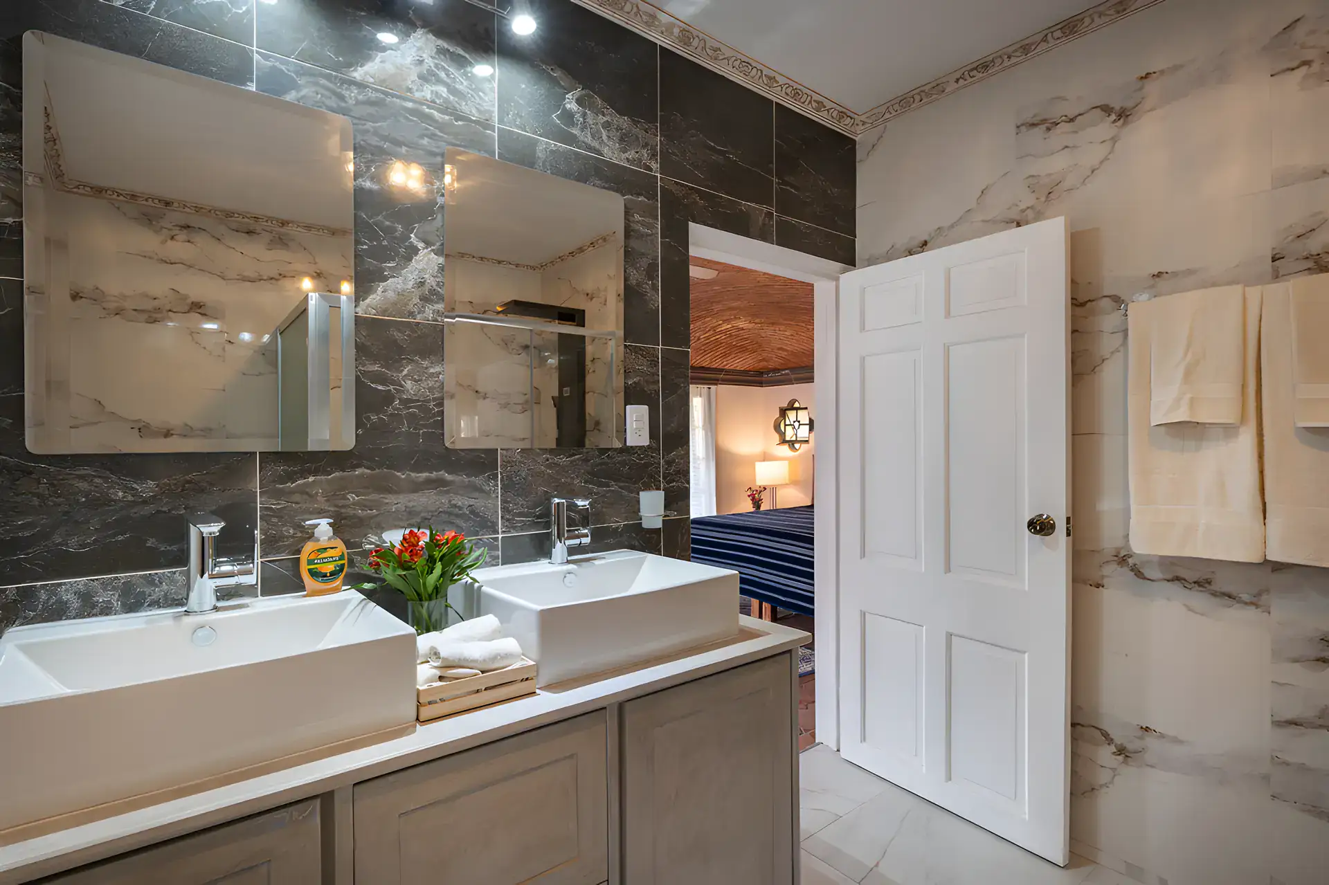 Villa Escondida, bathroom with a double vessel-sink vanity and marble-look tile, San Miguel de Allende