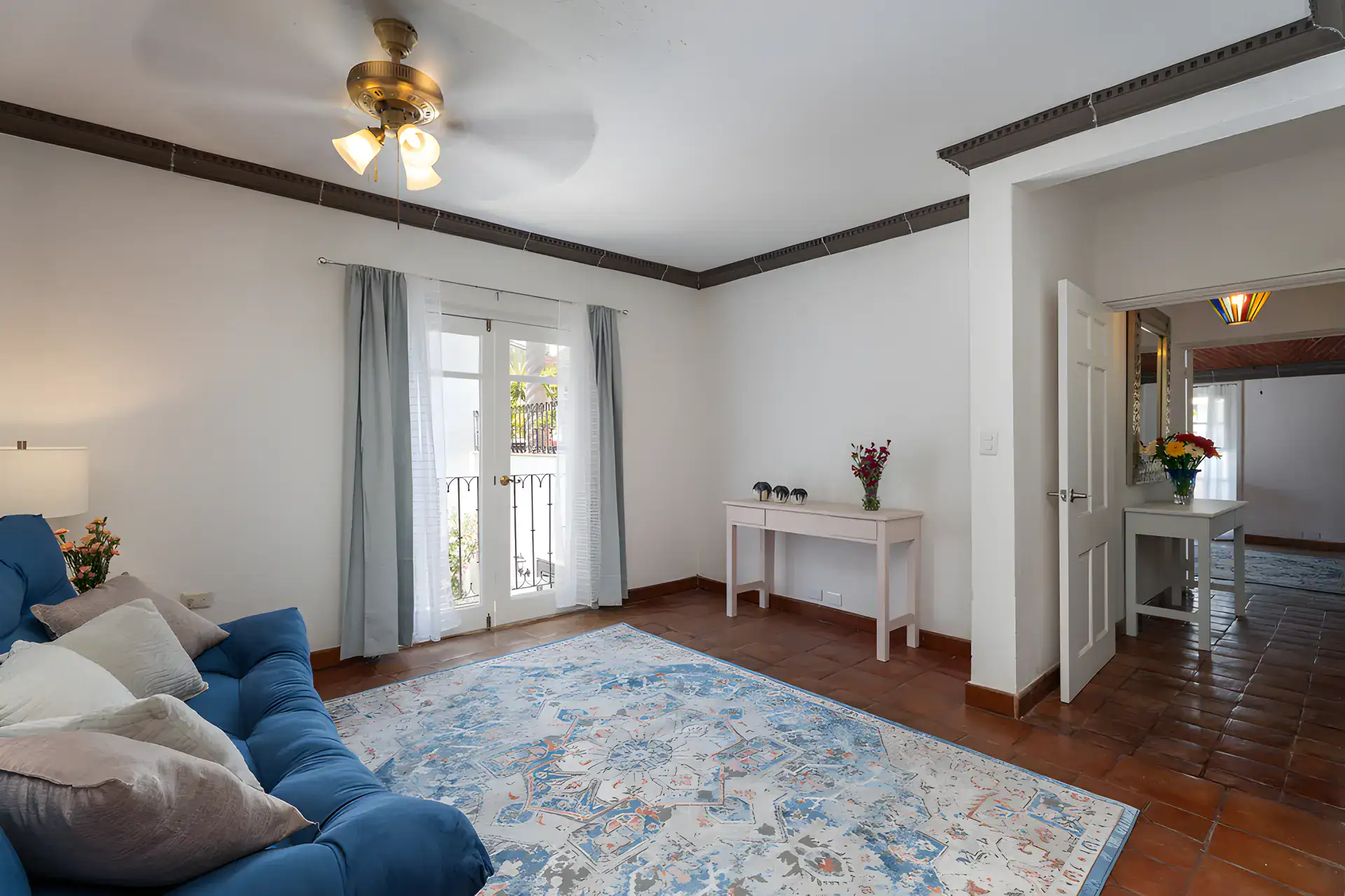 Villa Escondida, bedroom sitting area with a blue sofa, patterned rug and a ceiling fan, San Miguel de Allende