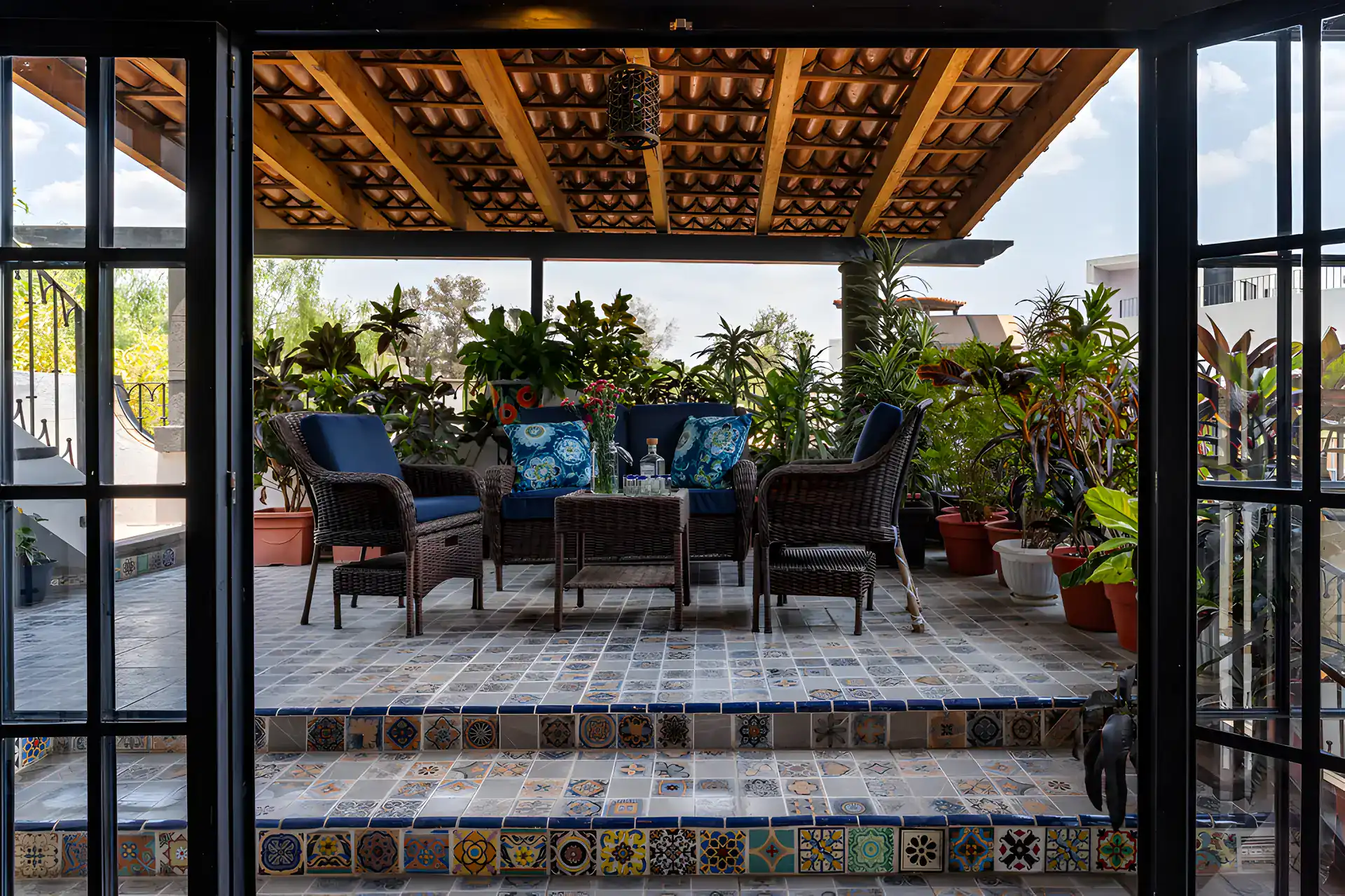 Villa Escondida, terrace with a covered seating area, blue wicker furniture and a tiled step, San Miguel de Allende