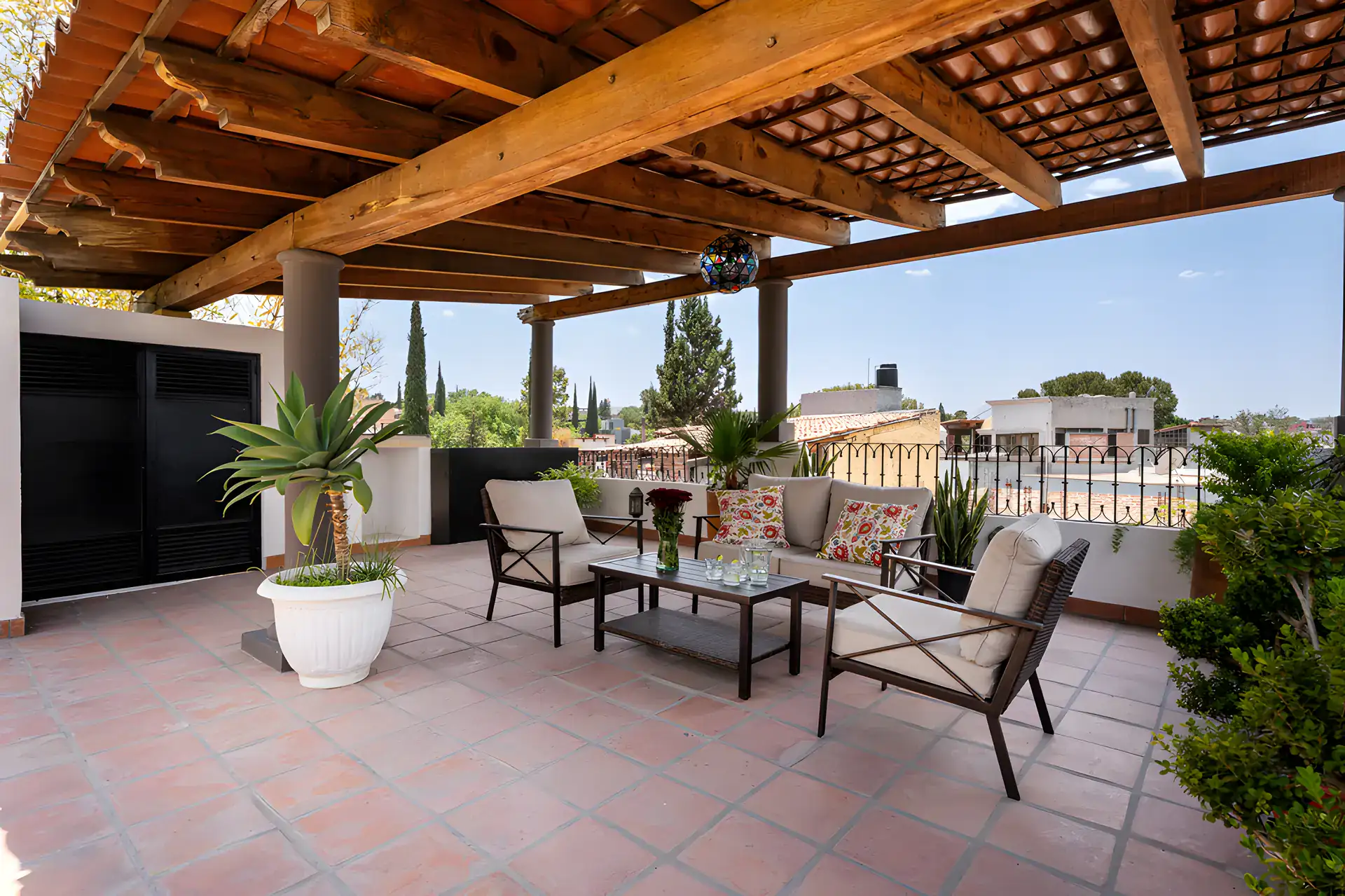 Villa Escondida, covered rooftop with outdoor seating, potted plants and a view over the rooftops, San Miguel de Allende