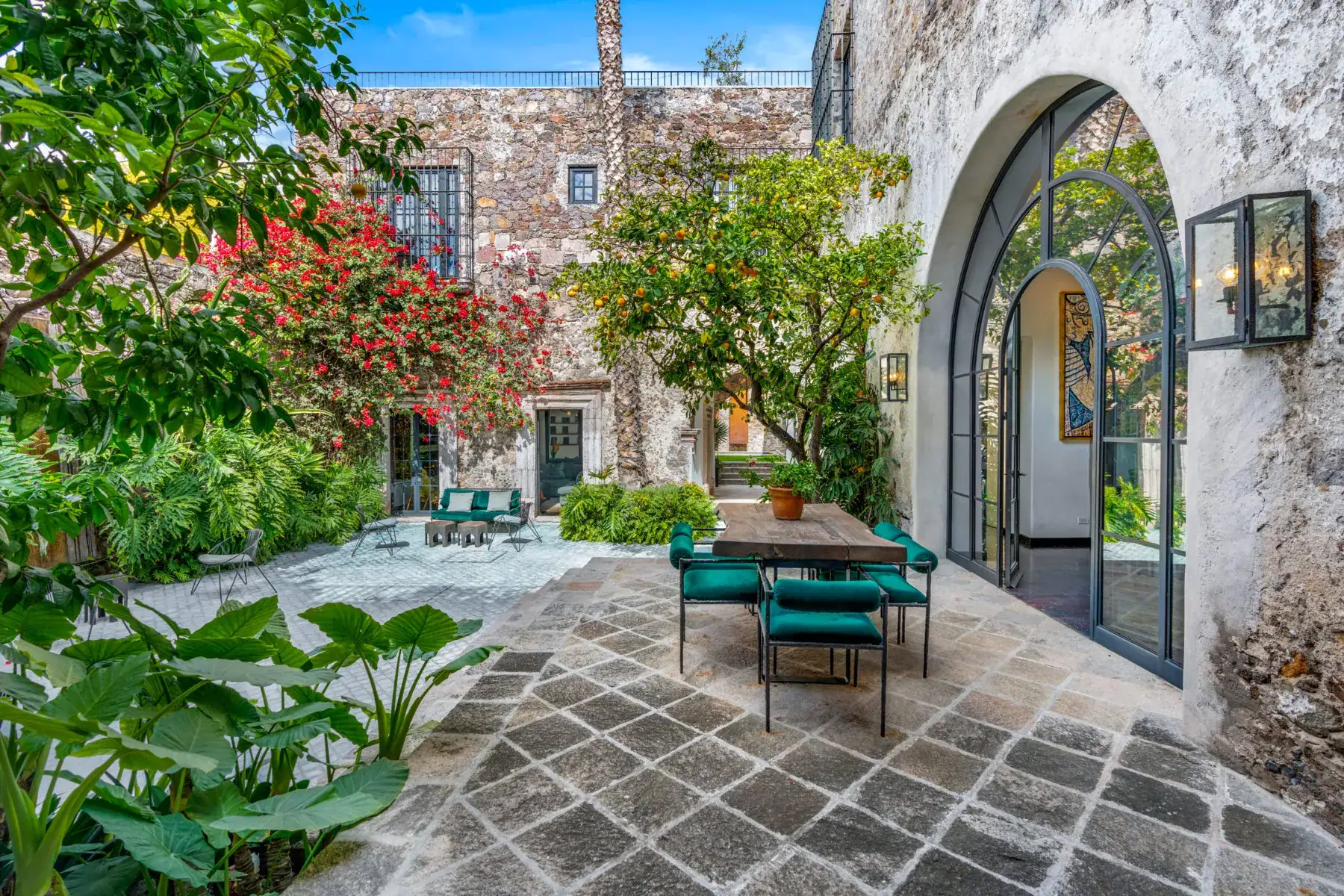Villa Garita, courtyard with an arched iron door, bougainvillea and a seating area, San Miguel de Allende