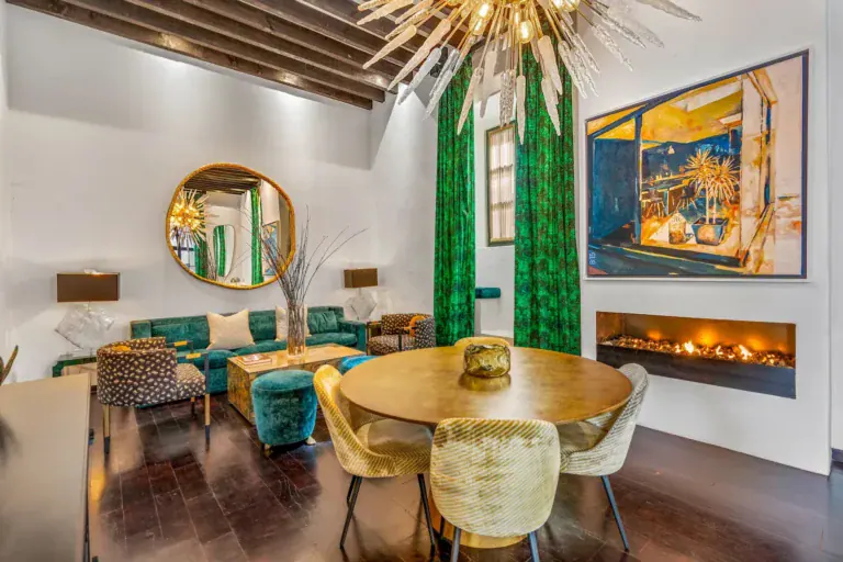 Villa Garita, living and dining area with a round table, fireplace and a gold sunburst chandelier, San Miguel de Allende
