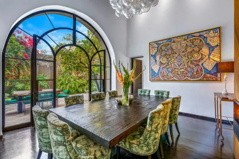 Villa Garita, dining room with a long wood table and an arched glass door to the garden, San Miguel de Allende