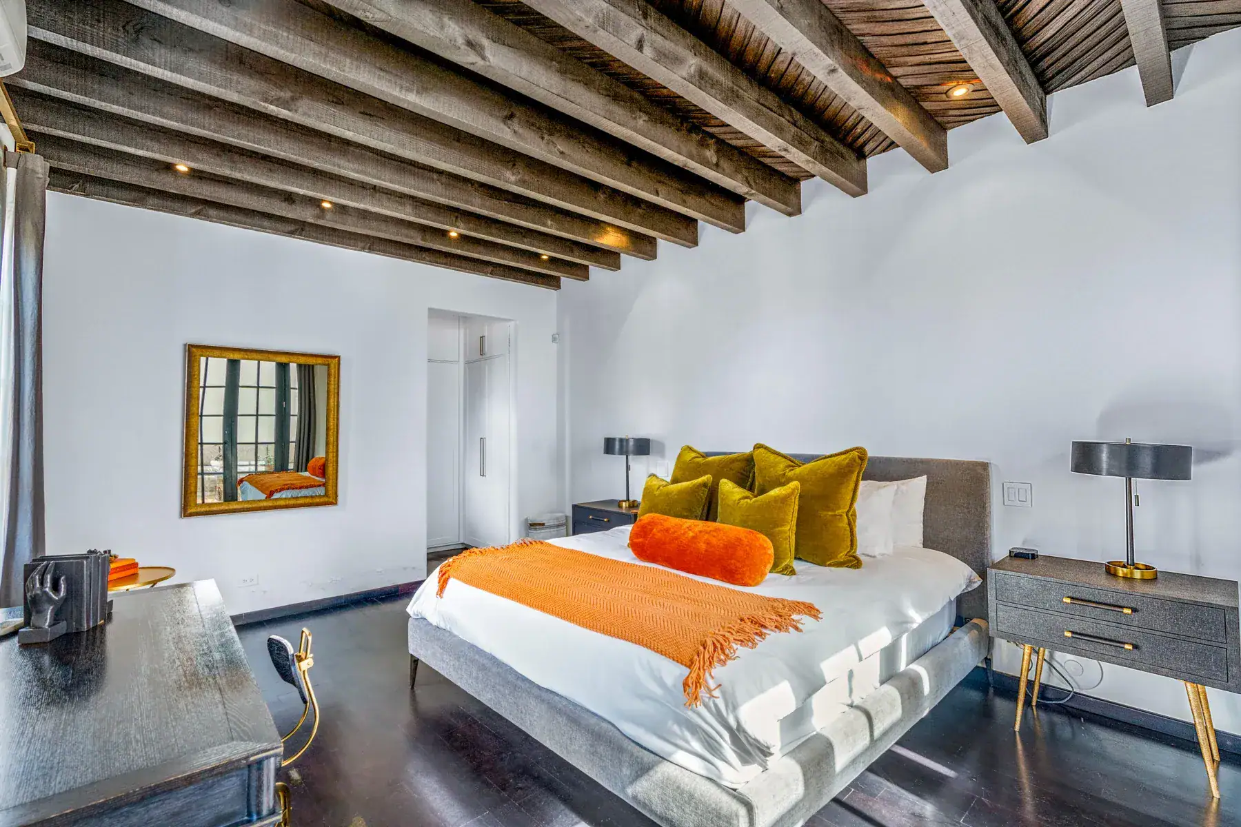 Villa Garita, bedroom with orange bedding, gold pillows and a beamed ceiling, San Miguel de Allende