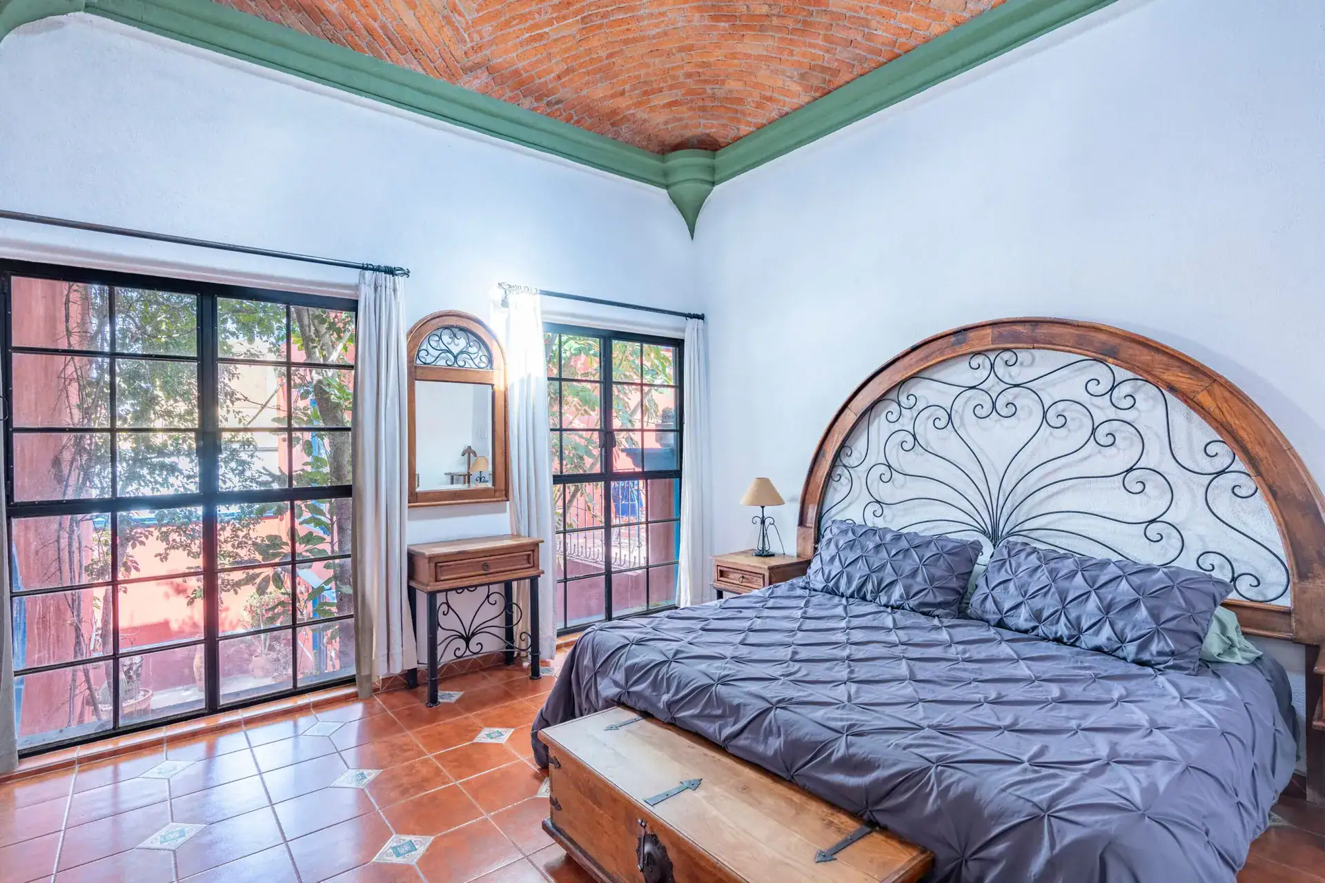 Villa Guacamayas, bedroom with a king bed and tall windows with French doors, San Miguel de Allende