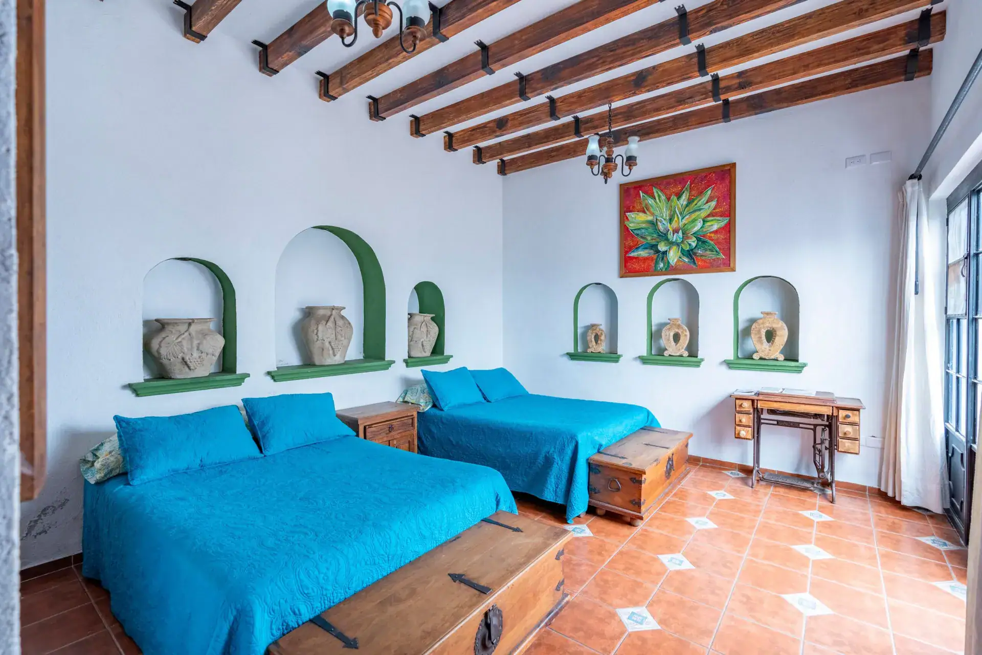 Villa Guacamayas, bedroom with two turquoise beds and arched shelf niches, San Miguel de Allende