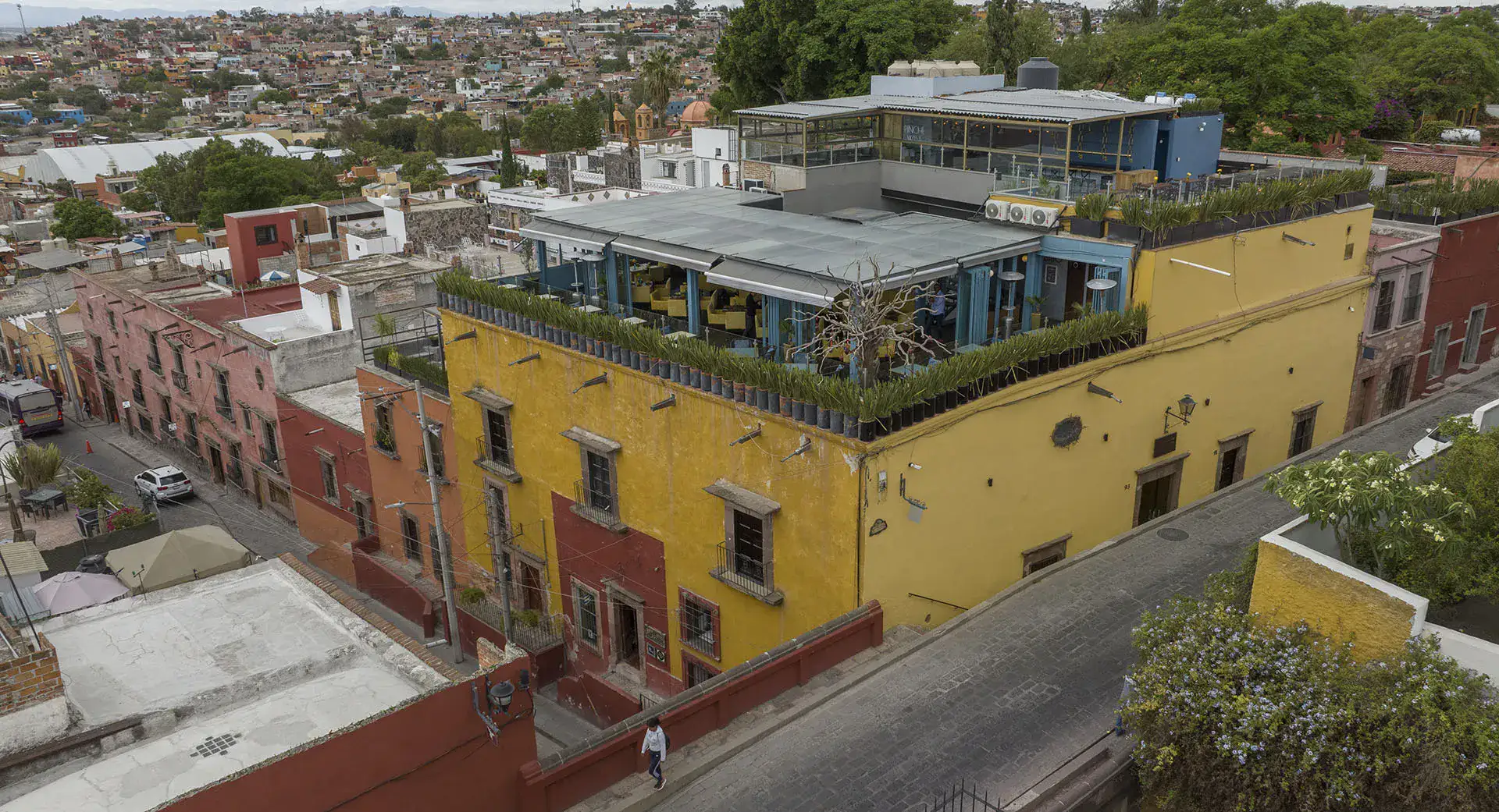 Villa Limón, aerial view of the yellow building with a rooftop terrace, San Miguel de Allende