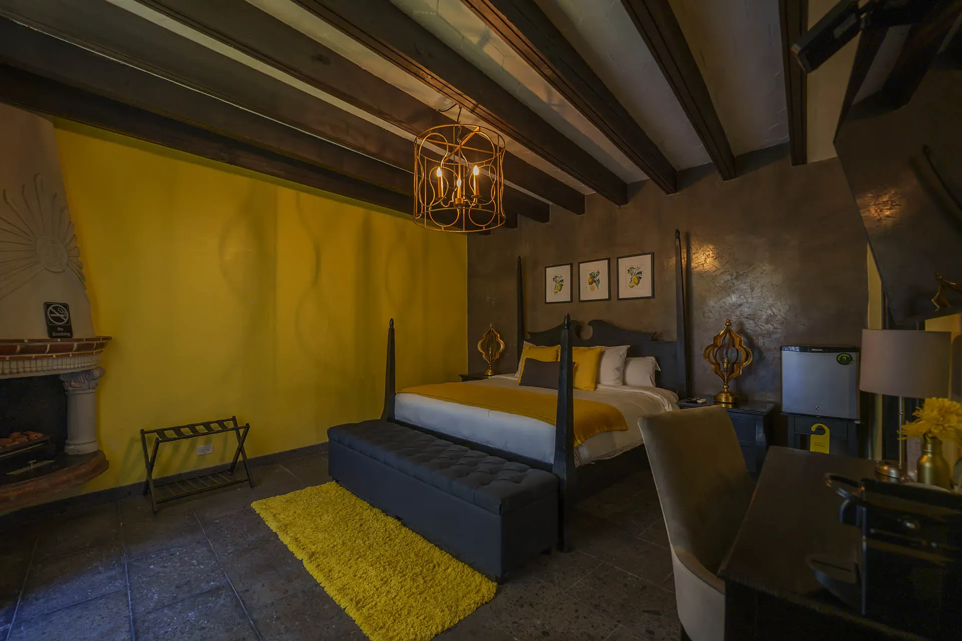 Villa Limón, suite with a four-poster bed, fireplace and yellow wall, San Miguel de Allende