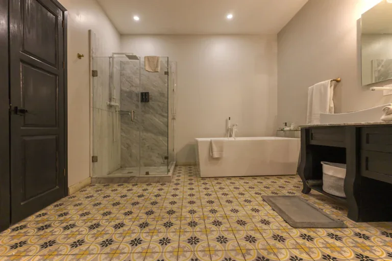 Villa Limón, bathroom with a freestanding tub, glass shower and patterned tile floor, San Miguel de Allende