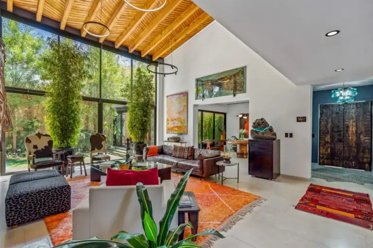 Villa Pacifica, double-height living room with a wood-slat ceiling, floor-to-ceiling glass and bamboo plants outside, San Miguel de Allende