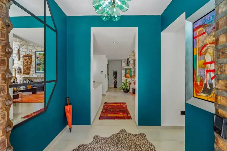 Villa Pacifica, entry hall with a teal feature wall, a steel-framed glass screen and a long corridor, San Miguel de Allende