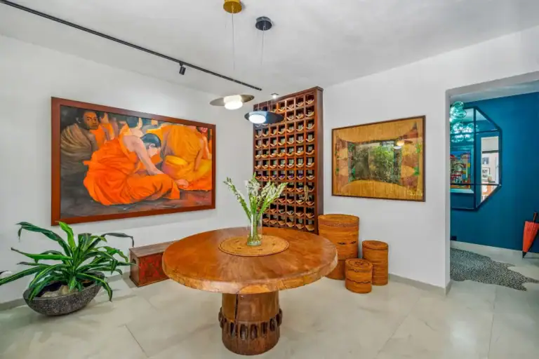 Villa Pacifica, round wood table, a wine rack, an orange painting and a view toward the entry, San Miguel de Allende