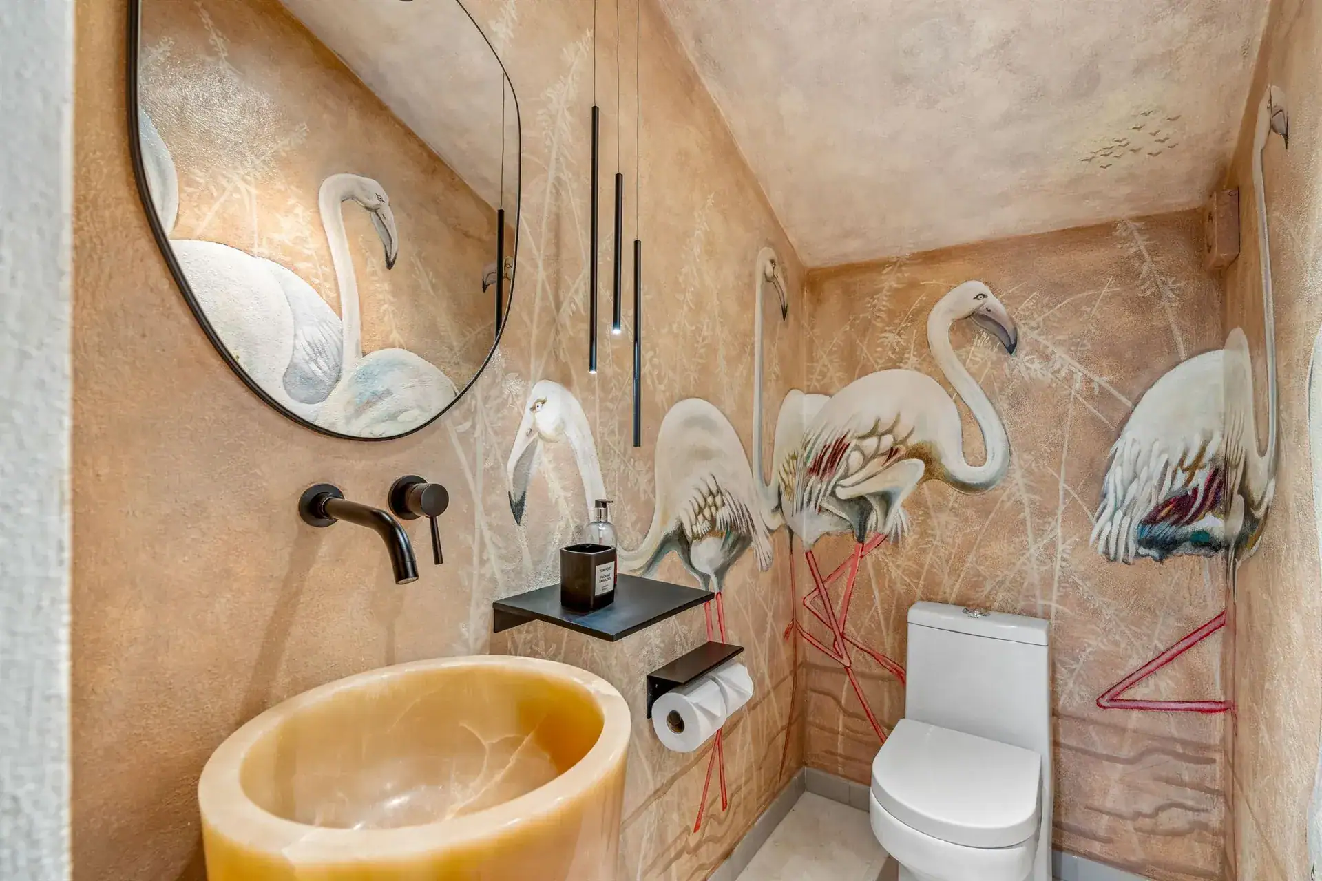 Villa Pacifica, powder room with a flamingo mural, an onyx sink and a round mirror, San Miguel de Allende