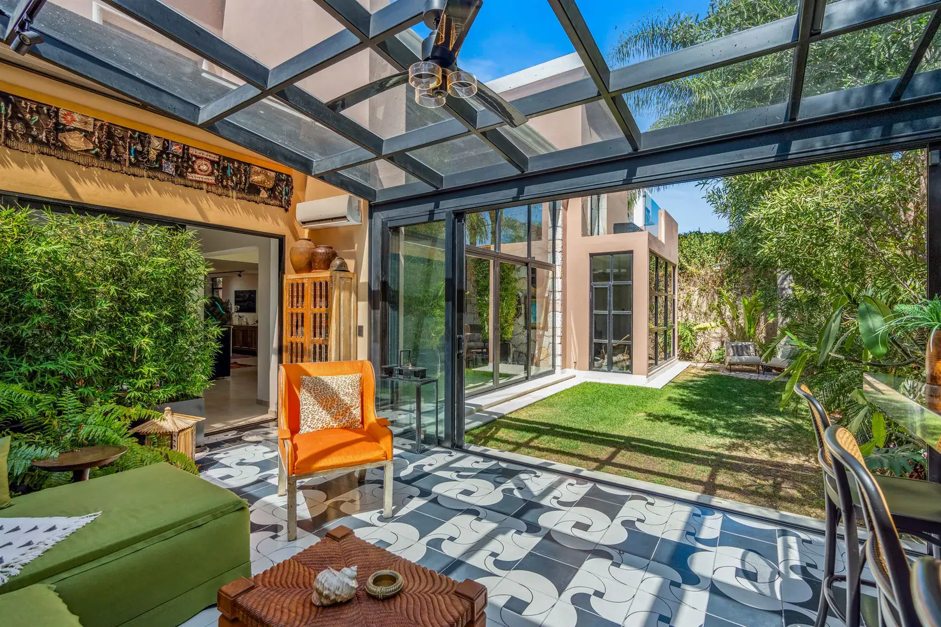 Villa Pacifica, glass-roofed lounge opening to the garden lawn and the glass-walled house, San Miguel de Allende