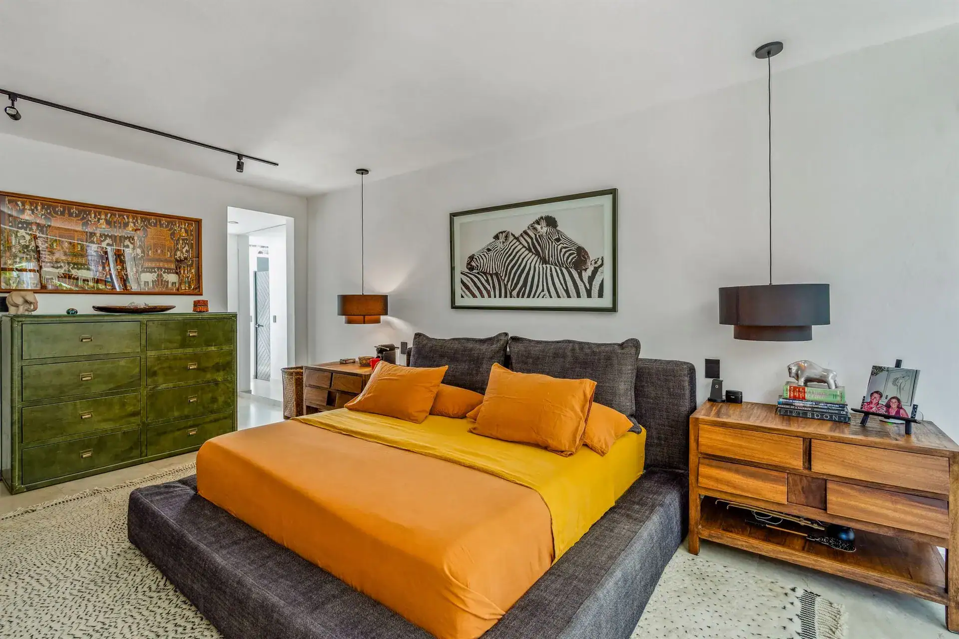 Villa Pacifica, bedroom with a dark platform bed, orange bedspread, a green dresser and a zebra print, San Miguel de Allende