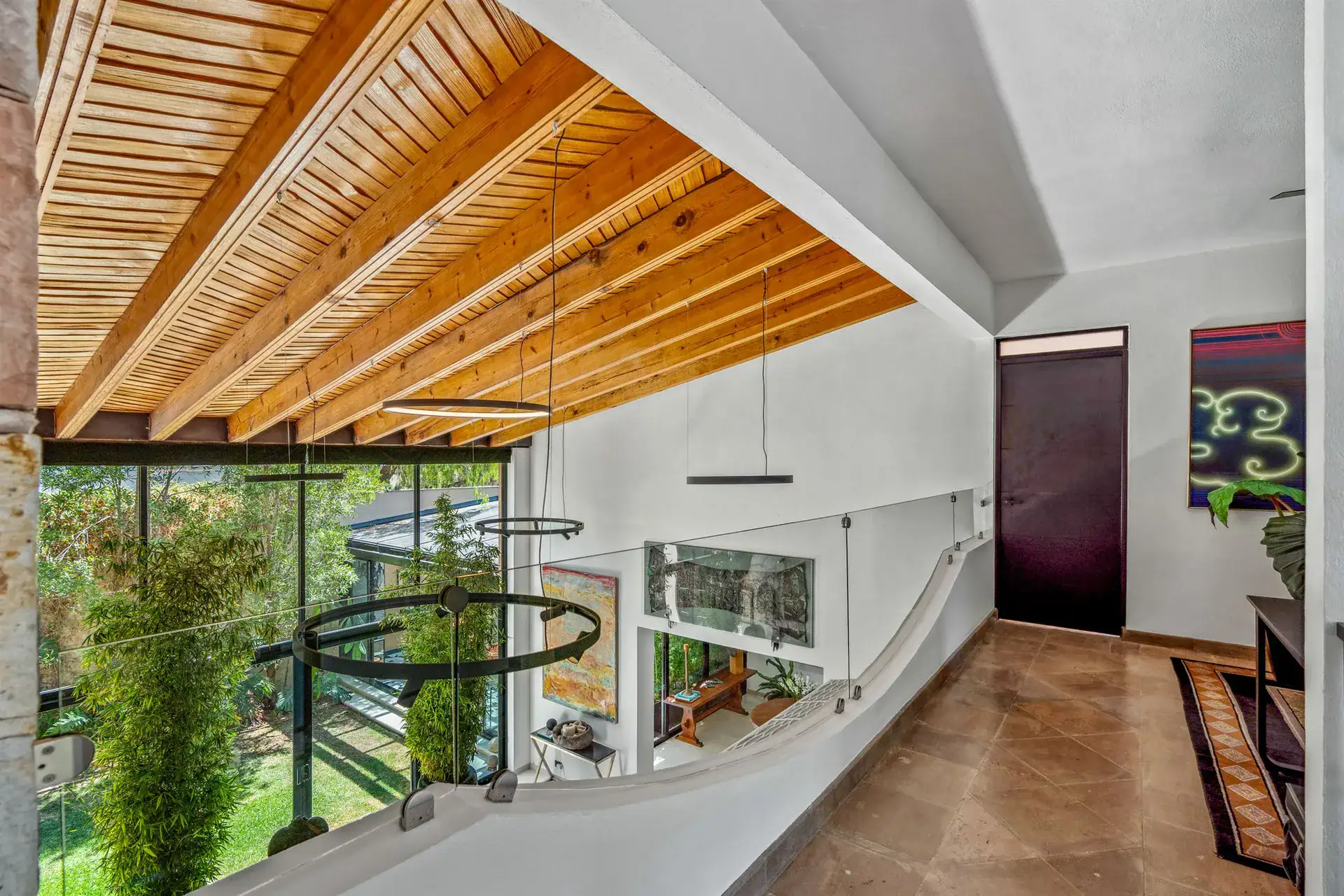 Villa Pacifica, upstairs corridor with a wood-slat ceiling, a glass balustrade and a view to the garden, San Miguel de Allende