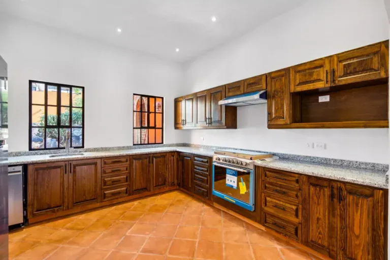 Villa Picasso, unfurnished kitchen with dark wood cabinets, granite counters and a stainless range, San Miguel de Allende