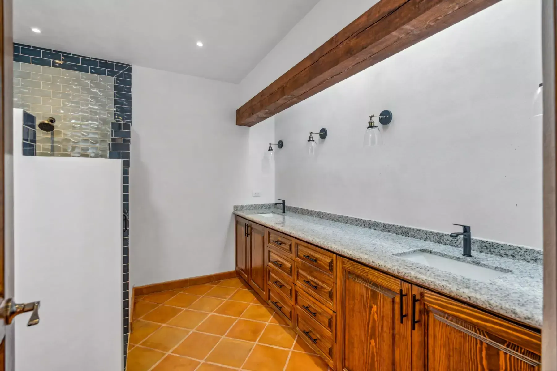 Villa Picasso, bathroom with a long wood vanity with a granite counter and a gray tile shower, San Miguel de Allende