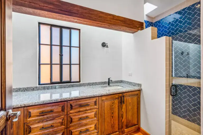 Villa Picasso, bathroom with a wood vanity with a granite counter, a window and a blue tile shower, San Miguel de Allende