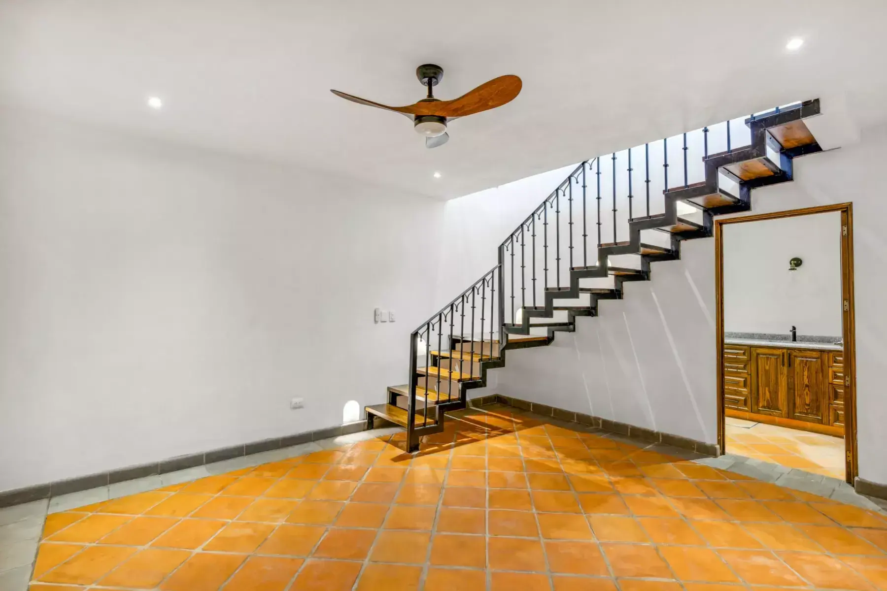 Villa Picasso, empty upper room with a floating staircase with black iron railing and a view to a bathroom, San Miguel de Allende